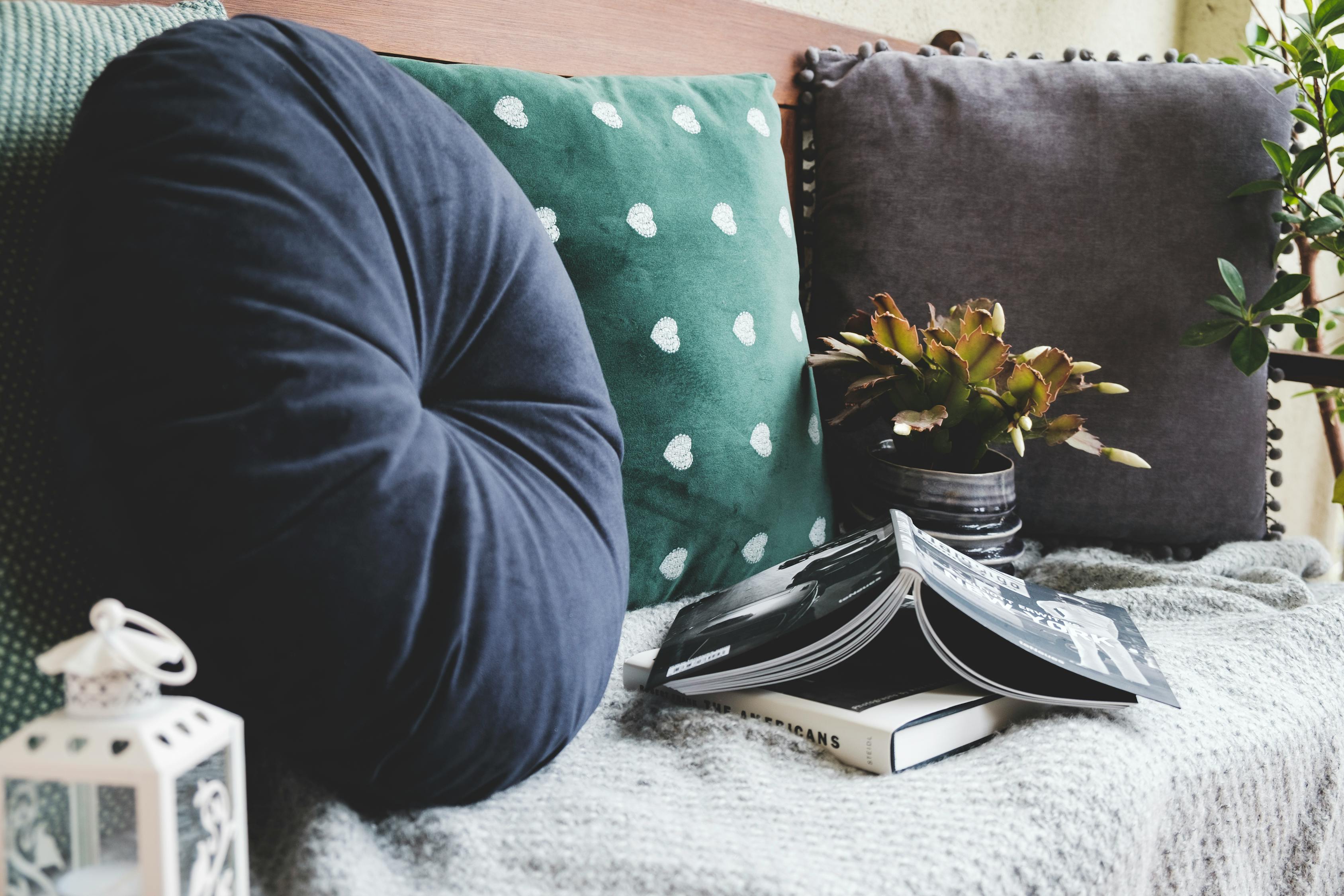 Canapé avec des coussins bleus et verts et un livre